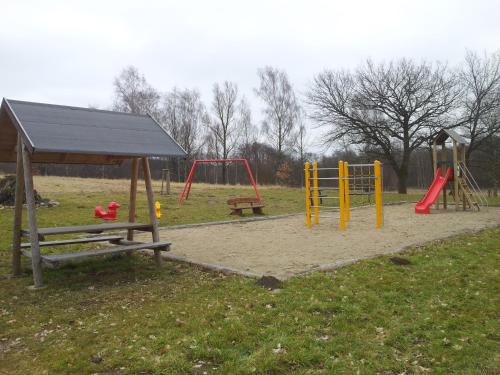 a park with two swings and a playground at Haus der 16 Seen in Krakow am See