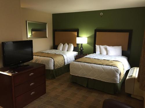 a hotel room with two beds and a flat screen tv at Extended Stay America - Atlanta - Marietta - Interstate N. Pkwy in Atlanta