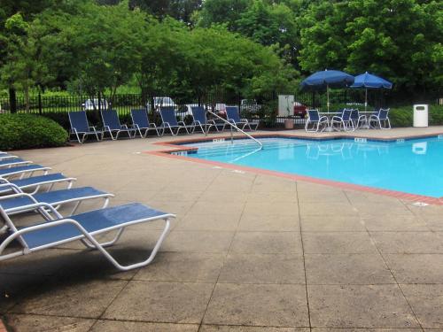 a swimming pool with lounge chairs and umbrellas at Extended Stay America - Atlanta - Marietta - Interstate N. Pkwy in Atlanta