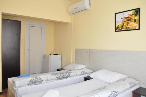 a room with two beds and a refrigerator at Guest Rooms Simona in Opanets