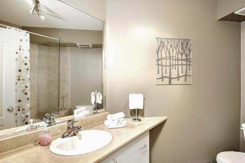 W łazience znajduje się umywalka i lustro. w obiekcie Condo 306 33 Chemin du Hameau by Les Chalets Alpins w mieście Stoneham