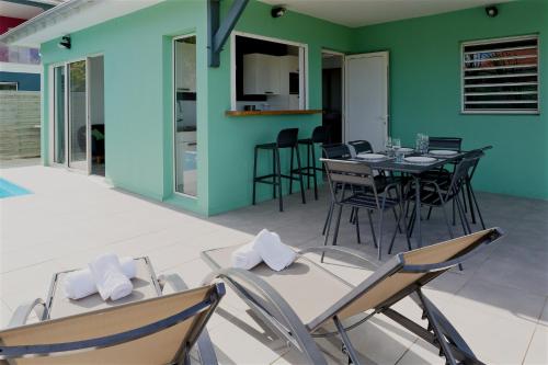 a dining room with a table and chairs at Les Villas Jalnas logement HATEYA in Les Trois-Îlets