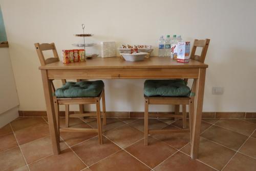 a wooden table with two chairs and a table at Agriturismo Villalta in Ponte Felcino