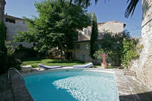 une piscine avec deux chaises et une maison dans l'établissement Maison De La Bourgade, à Uzès