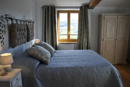 a bedroom with a bed and a window at La Grange Fleurie in Tramayes