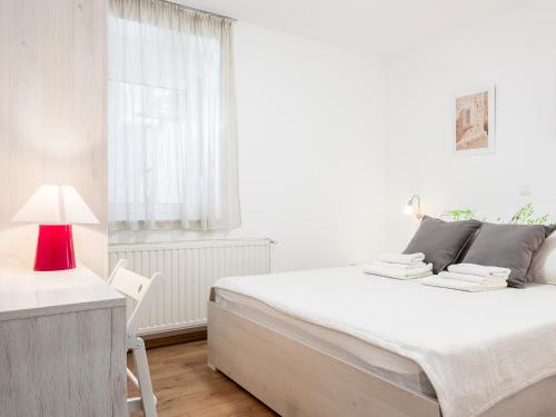 - une chambre blanche avec un grand lit et une lampe rouge dans l'établissement OLIVA 4 STARS, à Zagreb