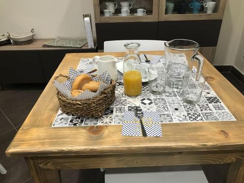 a wooden table with a basket of fruit and orange juice at B&B Geolja in Gioia Tauro