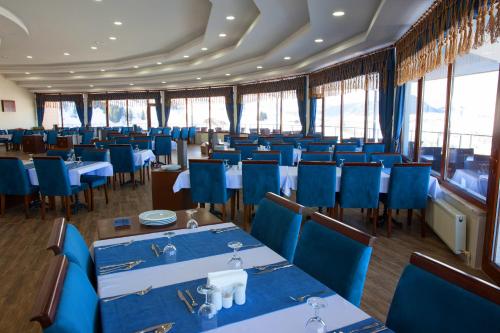 a dining room with blue tables and chairs at Black Forest Hotel in Savsat