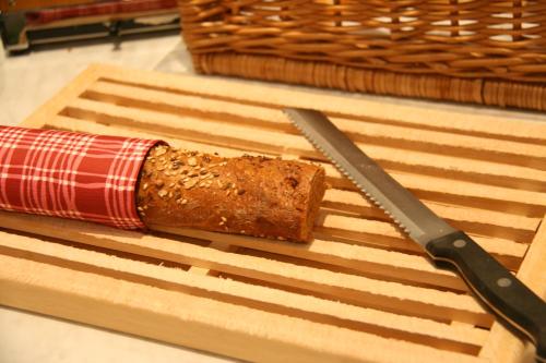 a piece of cake on a cutting board with a knife at Altstadt Hotel Mosser Villach mit Parkplatz in Villach