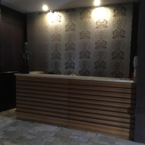 a reception desk in a room with a wall at Suites Parque Real in Quito