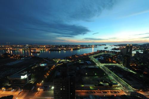 a view of a city at night with a river at Neo Sky Hotel in Kaohsiung