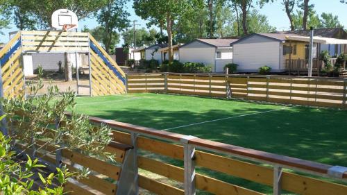 - un terrain de basket dans une clôture avec un panier de basket dans l'établissement Camping La Dune, à Vias