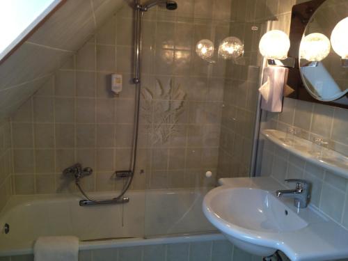 a bathroom with a shower and a sink and a tub at Hotel Fährhaus Ziehl in Geesthacht