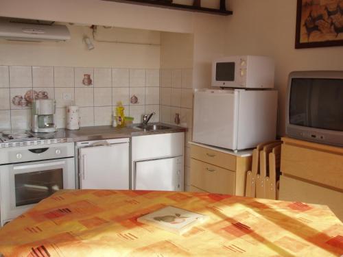 ビスカロッスにある112 RÉSIDENCE LES SABLES -004のキッチン(白い家電製品、テレビ付きテーブル付)