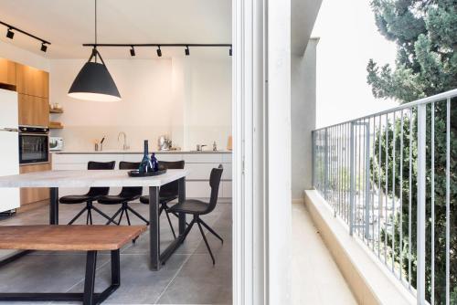 a kitchen and dining room with a table and chairs at Modern 2BR Apt w Private Parking in City Center by Sea N' Rent in Ramat Hash Sharon