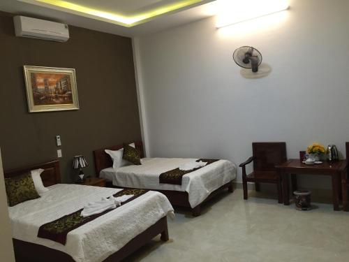 a hotel room with two beds and a table at Hoa Lu Hotel in Bản Giỏ (1)