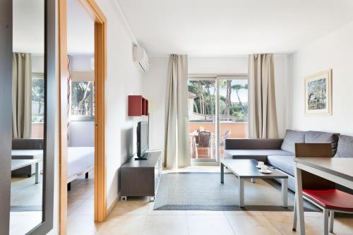 Aparthotel Bardon في كاستيلديفِيلس: غرفة معيشة مع أريكة وطاولة