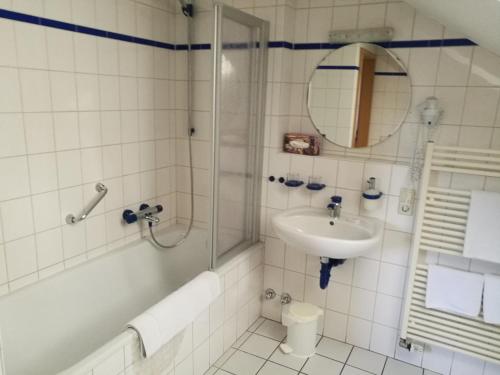 Un baño con ducha, lavabo y espejo. en Hotel Sonne, en Wolfach