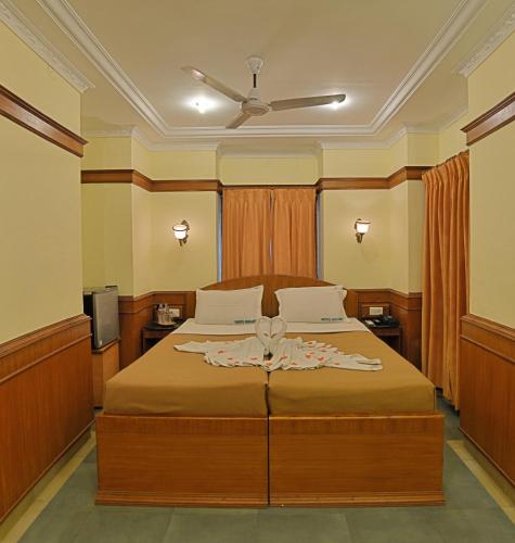 a bedroom with a bed and a ceiling fan at Hotel Mahabs in Mahabalipuram