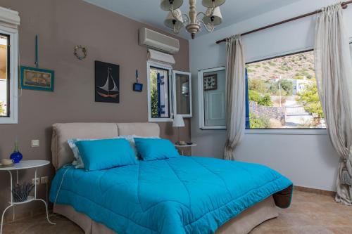 a bedroom with a blue bed and a window at Villa Euphoria in Aegina, A' Marathonas bay in Egina