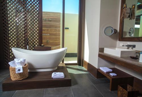 a bathroom with a large tub and a sink at NIZUC Resort & Spa in Cancún