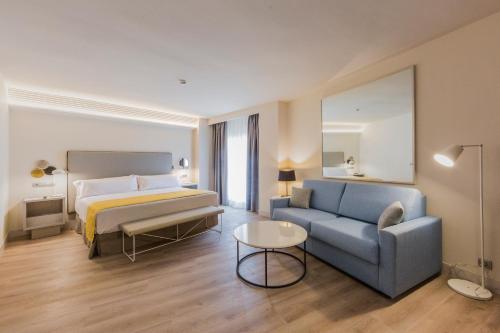 a hotel room with a bed and a couch at Catalonia Granada in Granada