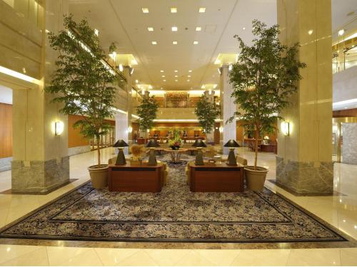 a lobby with tables and chairs in a building at Hotel Granvia Okayama in Okayama