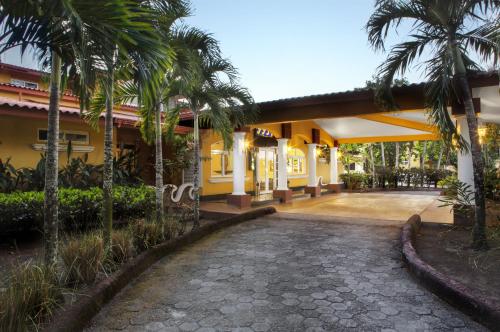 a courtyard of a building with palm trees at Las Olas Beach Resort in La Barqueta