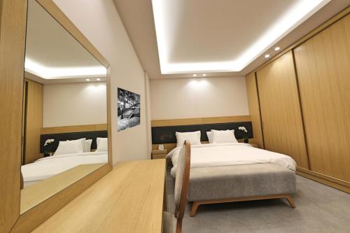 a bedroom with two beds and a large mirror at The Residence 649 in An Naqqāsh
