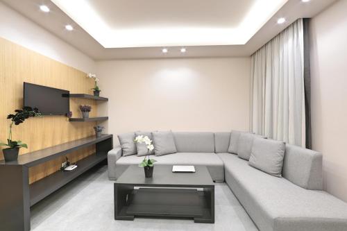 a living room with a couch and a tv at The Residence 649 in An Naqqāsh