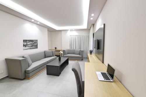 a living room with a couch and a table with a laptop at The Residence 649 in An Naqqāsh