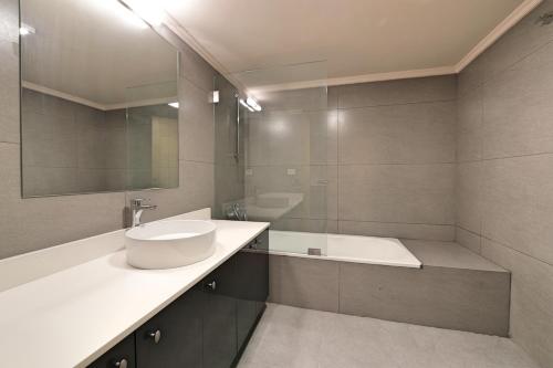 a bathroom with a sink and a tub and a mirror at The Residence 649 in An Naqqāsh