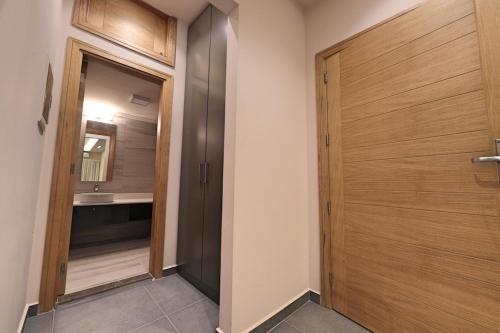 a bathroom with a wooden door and a sink at The Residence 649 in An Naqqāsh