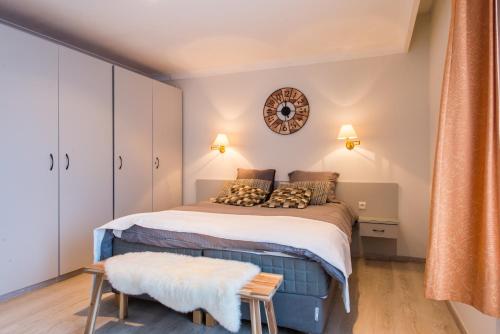 a bedroom with a bed and a clock on the wall at Inn Bruges in Bruges