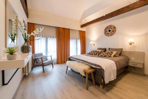 um quarto com uma cama, uma secretária e uma cadeira em Inn Bruges em Bruges