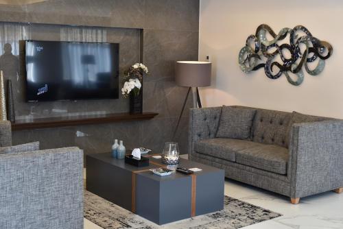 a living room with a couch and a tv at The Residence 649 in An Naqqāsh