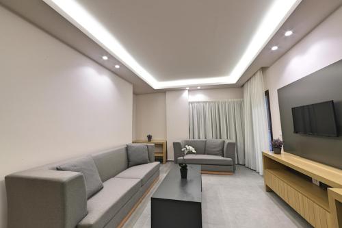 a living room with a couch and a flat screen tv at The Residence 649 in An Naqqāsh