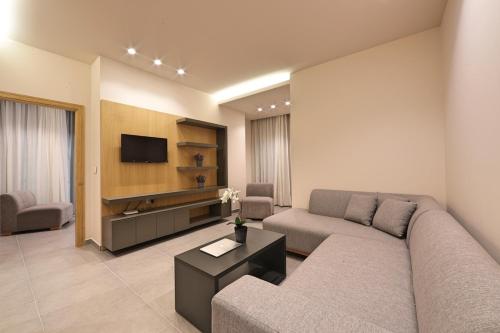a living room with a couch and a tv at The Residence 649 in An Naqqāsh