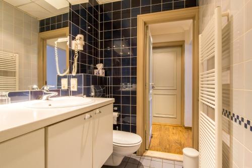 a bathroom with a toilet and a sink and a mirror at Inn Bruges in Bruges