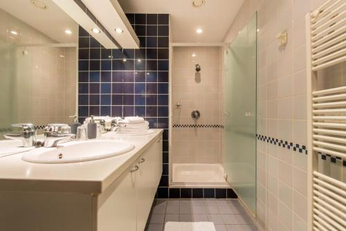 a bathroom with a sink and a shower at Inn Bruges in Bruges