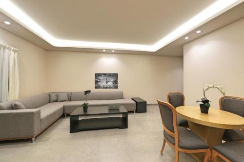 a living room with a couch and a table and chairs at The Residence 649 in An Naqqāsh