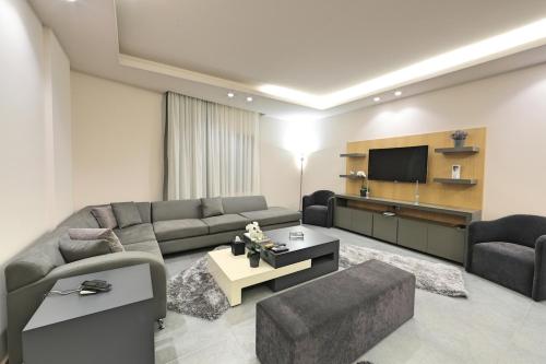 a living room with a couch and a tv at The Residence 649 in An Naqqāsh