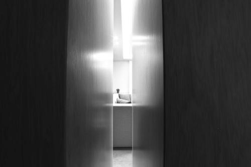 a black and white photo of a hallway with a chair at The Residence 649 in An Naqqāsh