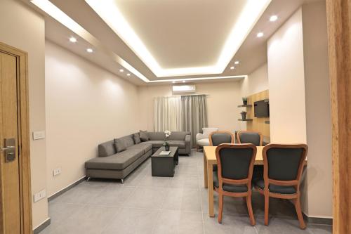 a living room with a couch and a table and chairs at The Residence 649 in An Naqqāsh
