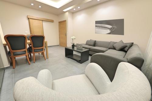 a living room with a couch and two chairs at The Residence 649 in An Naqqāsh