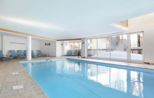 - une grande piscine d'eau bleue dans un bâtiment dans l'établissement Résidence Odalys Le Village, à Notre-Dame-de-Bellecombe