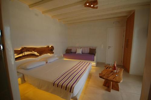 a bedroom with a large bed and a couch at Eternal Suites in Mýkonos City