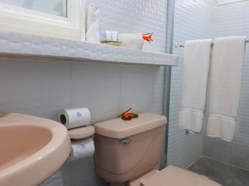 Baño blanco con aseo y lavamanos en Las Olas Beach Resort, en La Barqueta