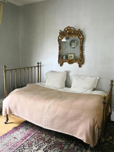a bedroom with a bed with a mirror on the wall at Maison d'hôtes Stella Cadente in Provins