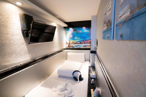 a room with a toilet with a television and towels at Kenting Space Capsule in Kenting